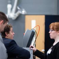 Students ask questions about a project